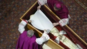 Before the wooden coffin is closed, Pope Benedict XVI’s personal secretary Archbishop Georg Gänswein and Monsignor Diego Giovanni Ravelli, the Vatican’s lead master of ceremonies for papal liturgies, place a white veil over the late pope’s face. The action on Jan. 4, 2023, is part of the funeral rites for popes.