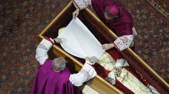 Before the wooden coffin is closed, Pope Benedict XVI’s personal secretary Archbishop Georg Gänswein and Monsignor Diego Giovanni Ravelli, the Vatican’s lead master of ceremonies for papal liturgies, place a white veil over the late pope’s face. The action on Jan. 4, 2023, is part of the funeral rites for popes.