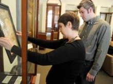 Archivist Leslie Knoblauch and Paul Wesley Bush place the etching on display. 