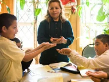 Nicolasa Chacon teaches third graders how to receive the Eucharist  