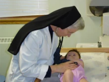 A Religious Sister of Mercy of Alma, MI cares for a child.