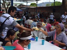 Colombian priests serving meals to Venezuelan emigrants. 