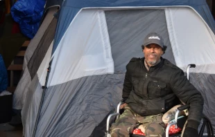 Mike Harris, who was one of the people displaced from K Street, poses for a picture in front of his tent under L Street.   Christine Rousselle/CNA