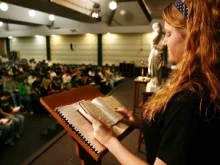 Rachel Stanley, senior at Bishop Carroll Catholic High School, leads about 150 fellow members of the God Squad in the Liturgy of the Hours. (Advance photo by Fred Solis.)