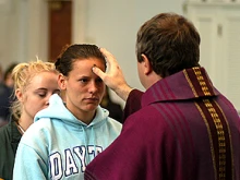 A priest distributes ashes on Ash Wednesday