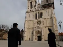 Cardinal Bozanic in front of the Assumption Cathedral, whose tower collapsed during a March 22 earthquake. 