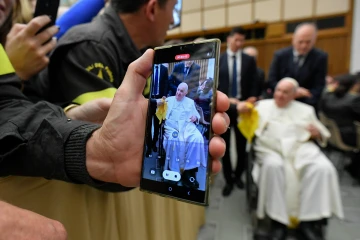 A person takes a photo of Pope Francis on a cell phone during a papal audience on Dec. 10, 2022.