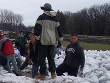 Volunteers help place sandbags around Cardinal Muench Seminary (