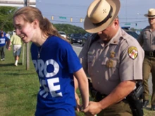 A Maryland state trooper handcuffs Joan Walsh, 18.