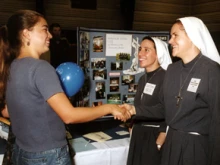 A student talking to sisters at a vocation fair at Franciscan University