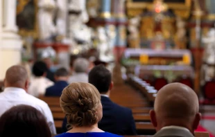 People are sitting in the church during mass.  