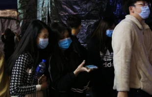 Pedestrians wear surgical masks in Hong Kong following coronavirus outbreak.   katherinekycheng/Shutterstock