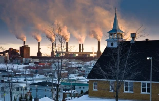 Church building overlooking smokestack.   Daniel Zuckerkandel/Shutterstock