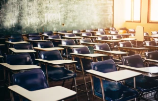 Wooden row lecture chairs in classroom. Via Shutterstock 