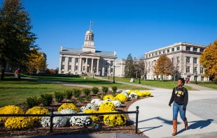 A student walks across campus at the University of Iowa, in Iowa City, Iowa. University of Iowa via flickr