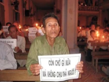 A protestor participates at a candle light vigil for the arrested Catholics