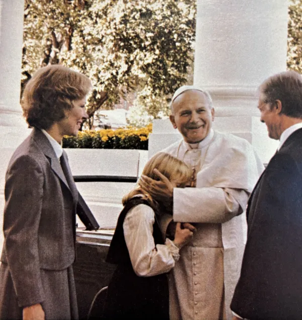 As U.S. President Jimmy Carter and First Lady Rosalynn Carter look on beaming, Pope John Paul II greets then-eleven-year-old first daughter Amy Carter upon her arrival at the White House on October 6, 1979. Photo credit: U.S. Government Printing Office