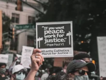 A participant holds up a sign with a quote from St. Paul VI at a June 2020 rally in Atlanta. Credit: Maria Oswalt via Unsplash.