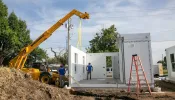 Workers assemble units in Catholic Charities of the Archdiocese of Oklahoma City's "Caritas Casitas" neighborhood on Tuesday, Aug. 13, 2024.