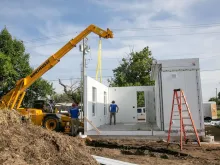 Workers assemble units in Catholic Charities of the Archdiocese of Oklahoma City's "Caritas Casitas" neighborhood on Tuesday, Aug. 13, 2024.