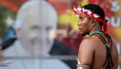 A man stands in front of a poster of Pope Francis outside APEC Haus in Port Moresby, Papua New Guinea, to welcome the Roman pontiff, Sept. 7, 2024.