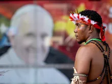 A man stands in front of a poster of Pope Francis outside APEC Haus in Port Moresby, Papua New Guinea, to welcome the Roman pontiff, Sept. 7, 2024.