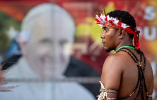 A man stands in front of a poster of Pope Francis outside APEC Haus in Port Moresby, Papua New Guinea, to welcome the Roman pontiff, Sept. 7, 2024. Credit: Daniel Ibáñez/CNA