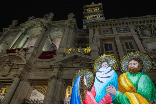 An illuminated Nativity scene display stands before the baroque facade of the Basilica of St. Mary Major at night, with the church's iconic bell tower visible against the dark Roman sky, on Jan. 1, 2025. Credit: Daniel Ibáñez/CNA