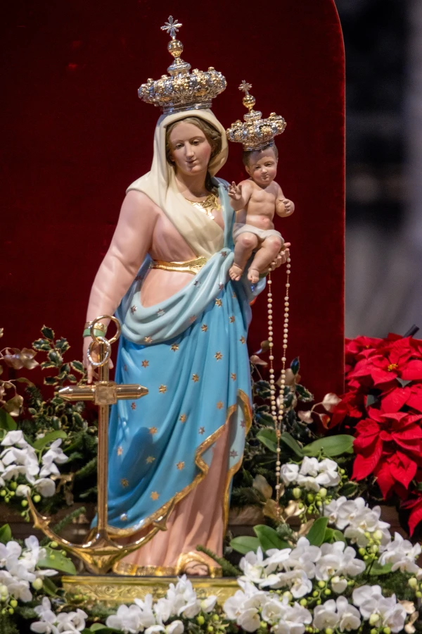 A statue of Mary and the child Jesus, adorned with crowns and surrounded by poinsettias and white orchids, is displayed during the New Year's Day Mass at St. Peter's Basilica. Credit: Daniel Ibáñez/CNA