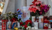 A makeshift shrine with devotional candles, flowers, and images of Pope Francis appears outside Rome’s Gemelli Hospital on Feb. 22, 2025.