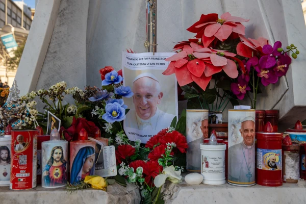 Kuil darurat dengan lilin renungan, bunga, dan gambar Paus Francis muncul di luar Rumah Sakit Roma Gemelli pada 22 Februari 2025. Kredit: Daniel Ibáñez/CNA