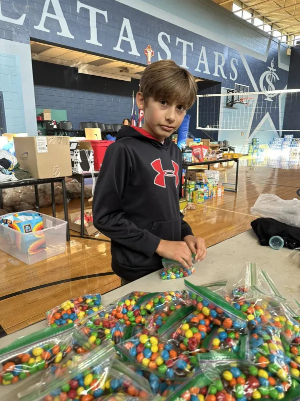 A young volunteer bags candy at Immaculata Catholic School in Hendersonville, North Carolina, October 2024. Credit: Immaculata Catholic School