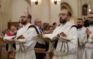 The entrance into the Franciscan church in Aleppo, Syria, of the twins George and Johnny Jallouf, friars of the Custody of the Holy Land, who were ordained priests on July 6, 2024. The two ordinands are wearing the priestly vestments with which they were clothed during the ordination rite. They were 15 when the war in Syria broke out. Their vocation was born and grew amid the Battle of Aleppo. “I tried to attend Mass every day,” George recounted. “I was afraid, but I kept repeating to myself ‘I fear nothing because you are with me.’ This phrase guided me, reassured me, gave me peace.” Credit: Photo courtesy of the Tawk Center