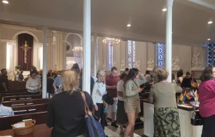 Crowds exit Holy Trinity Catholic Church in Washington, D.C., after the June 14, 2023, "Pride Mass" with "Progress Pride" flags visible in the back of the church. Peter Pinedo/ CNA