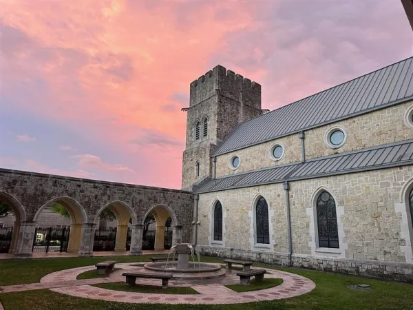 The Cathedral of Our Lady of Walsingham in Houston is the beating heart of the Ordinariate of the Chair of Saint Peter. Surrounded by rows of white stone columns, the front of the cathedral is marked by a castle-like tower with four figures representing the four Gospels jutting out of the top. Credit: Photo courtesy of the Cathedral of Our Lady of Walsingham