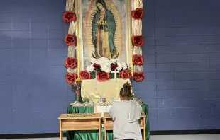 A migrant woman prays in front of an image of Our Lady of Guadalupe at a migrant shelter in McAllen, Texas, run by Catholic Charities of the Rio Grande Valley. Credit: Peter Pinedo/CNA