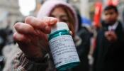 A pro-abortion activist displays abortion pills as she counter-protests during a pro-life rally on March 25, 2023, in New York City.