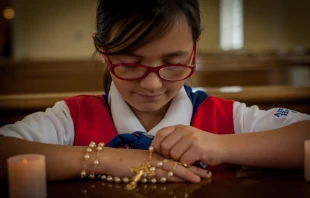 American Heritage “Tenderheart” girl prays the rosary. Credit: Photo courtesy of American Heritage Girls