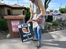 Longtime pro-life advocate Lynn Dyer places a sign that reads “Life Never a Mistake” on public property in front of Camelback Family Planning, an abortion clinic in Phoenix, on April 18, 2024.