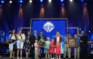 Joe and Tiffany Ampe, with 11 of their 13 children, accept the International Family of the Year award from Supreme Knight Patrick E. Kelly at an awards session prior to the 142nd Supreme Convention in Québec City on Aug. 5, 2024. Joe Ampe, a Knight from Marquette, Michigan, and his family were recognized for their service to their parish and their community, particularly their efforts to deliver humanitarian aid to Ukraine, the home country of three of their adopted children. Credit: Paul Haring