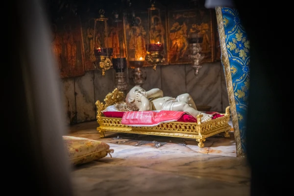 The statue of the Baby Jesus rests on the silver star in the Grotto of the Nativity in Bethlehem at the end of the Christmas Eve Mass on December 24, 2024. Credit: Marinella Bandini