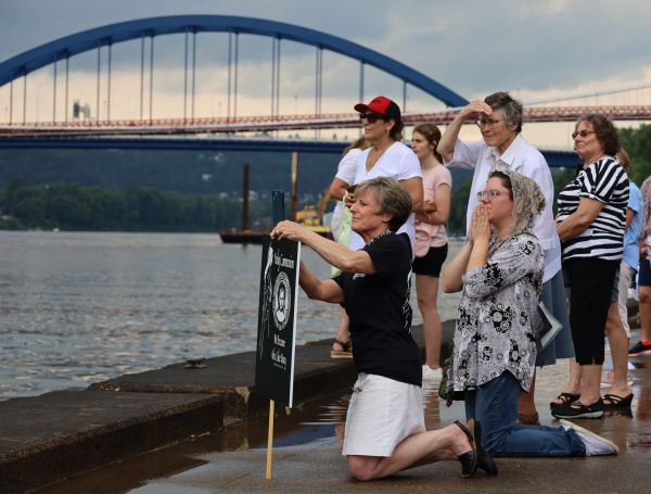 Pilgrims kneel as the Blessed Sacrament passes aboard the vessel "Sewickley" on the Ohio River near Steubenville, Sunday, June 23, 2024. Credit: Colleen Rowan