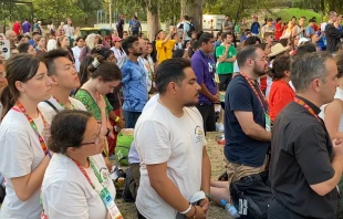 Pilgrims kneel in adoration at a World Youth Day event in Lisbon, Portugal, Aug. 2, 2023. The event was hosted by the U.S. bishops’ conference and featured a talk by Bishop Robert Barron culminating in a eucharistic procession and Holy Hour. Credit: Claudette Jerez/EWTN News video screen shot