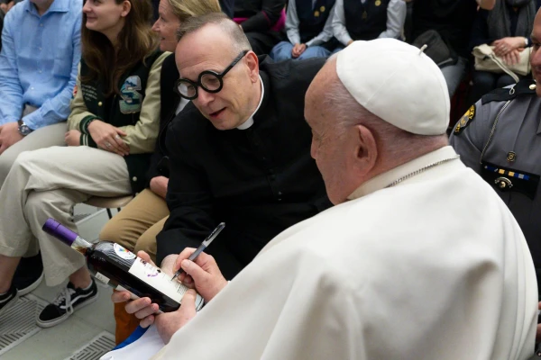 Pope Francis signs two bottles of bourbon presented to him by Father Jim Sichko at the Vatican, May 1, 2024. Credit: Courtesy of Sotheby’s