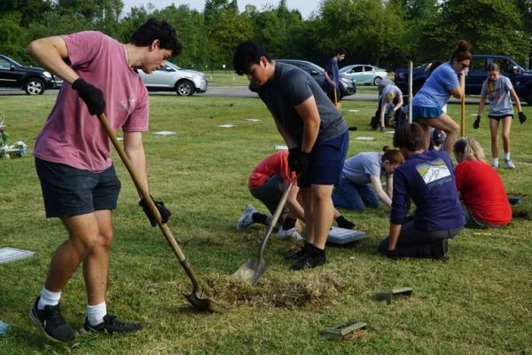 Students use shovels to locate a temporary marker at a gravesite in Meadow View Cemetery in Louisville, Kentucky, Sept. 21, 2024. Credit: The Record/Ruby Thomas