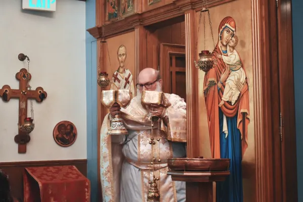 Father Joel Barstad processes from the altar through the church, a small room, with the gifts of bread and wine before the consecration during Divine Liturgy on June 8, 2024. Credit: Kate Quiñones/CNA