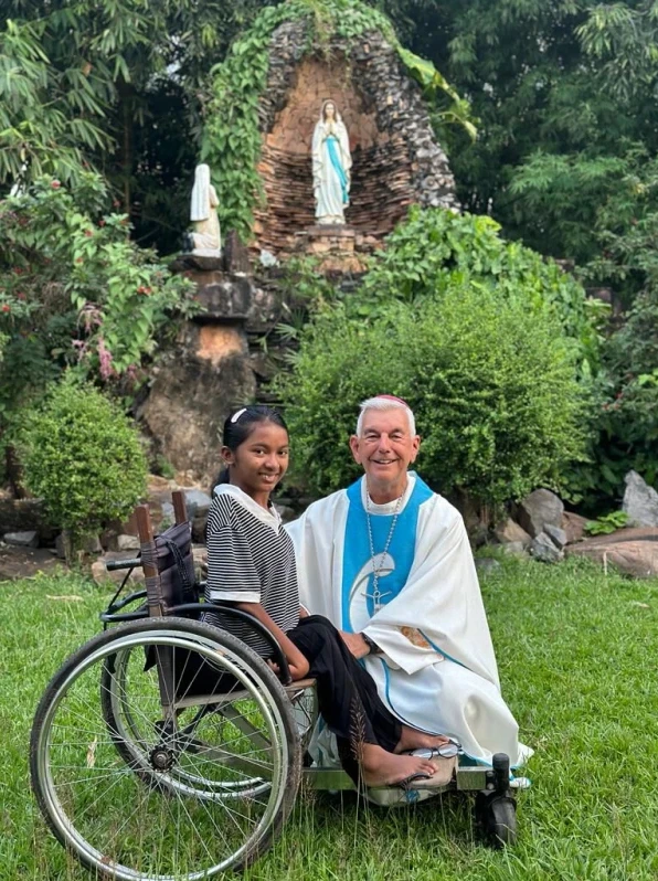 Father Kike Figaredo with a child on the grounds of the mission. Credit: Courtesy of Father Kike Figaredo