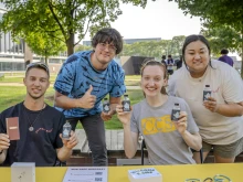 Left to right, Victor Fenik, J.P. Ledermann, Jocelyn Reiter, and Anna Picasso distribute bottles of holy water to new and returning students during the involvement fair on Aug. 26, 2024, at the College for Creative Studies in Detroit. Members of Detroit Catholic Campus Ministry have been distributing holy water at the start of the academic year at local colleges and universities for the past three years.