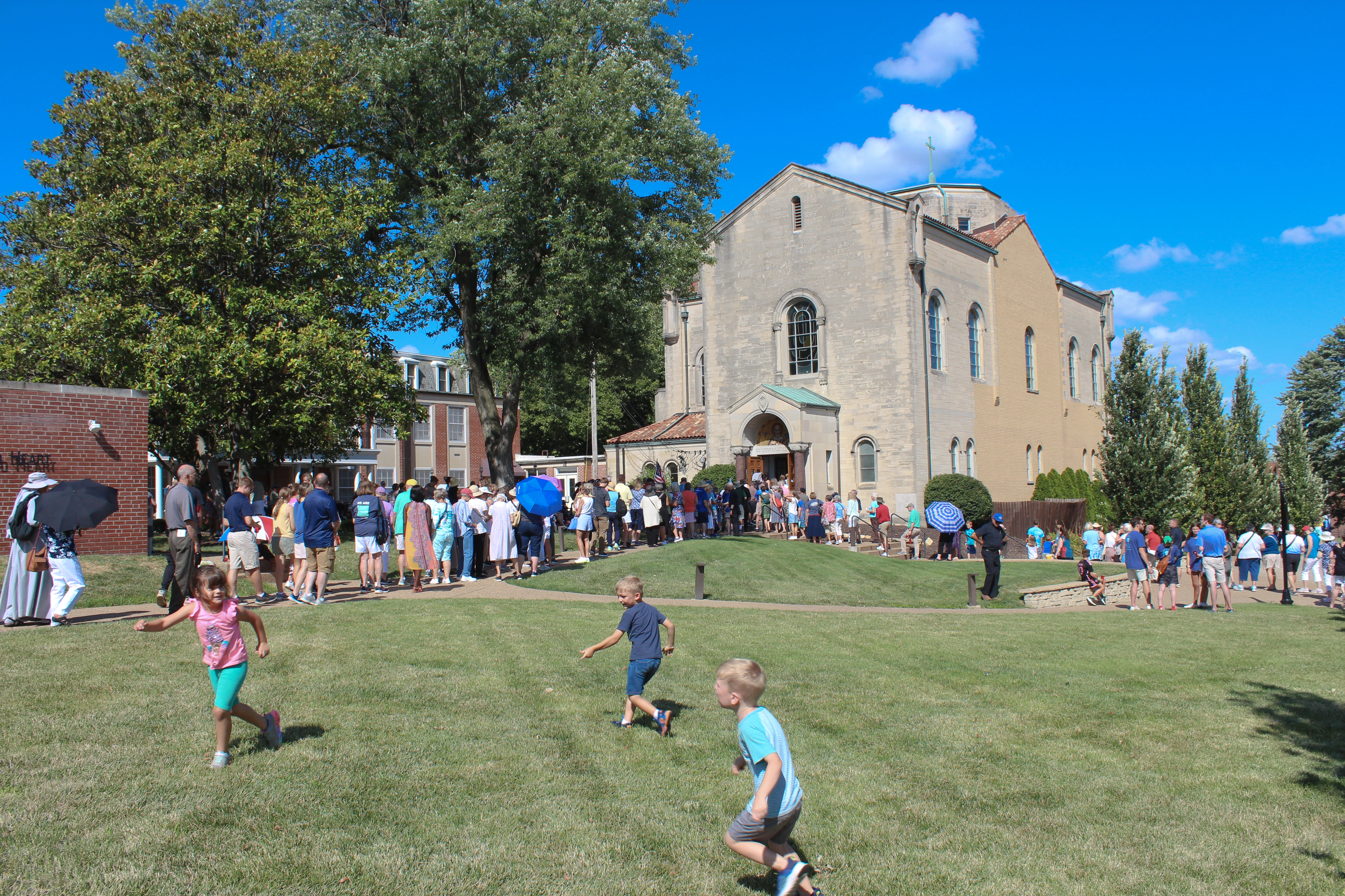 Children play as procession participants wait to enter the Shrine of St. Rose Philippine Duchesne for adoration.?w=200&h=150