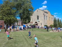 Children play as procession participants wait to enter the Shrine of St. Rose Philippine Duchesne for adoration.